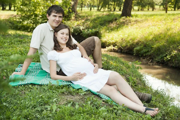 Těhotná Manželka Její Manžel Leží Zelené Trávě Dívá Kameru — Stock fotografie