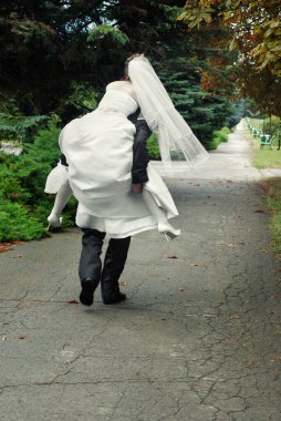 Damat gelinle parkın arka bahçesinde kaçıyor. 