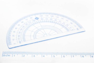 Arka planda bulanık açılı açıölçer ile mavi ölçüm cetvelinin yakınlaştırılması