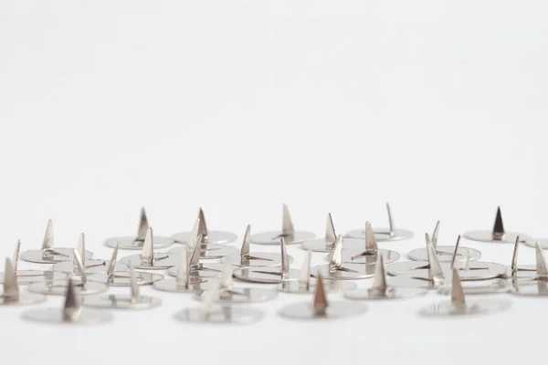 Bunch of old-fashioned metal drawing pins turned upside down with selective focus