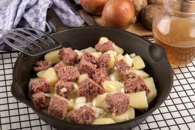 very irish meal, raw corned beef hash in a cast iron pan clipart