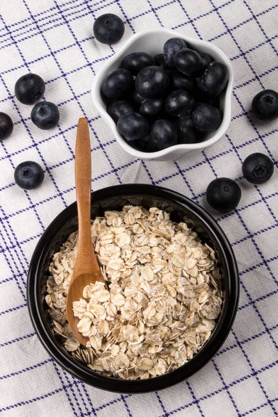 传统的爱尔兰燕麦片在一个黑色的碗与木勺和健康的蓝莓 — 图库照片