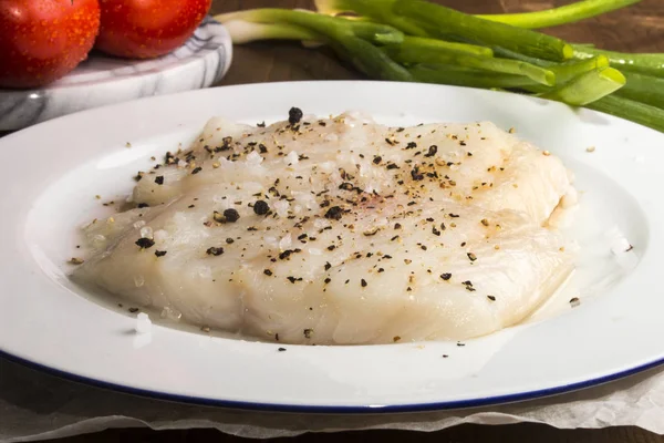 Bacalhau cru com pimentão esmagado em uma chapa — Fotografia de Stock