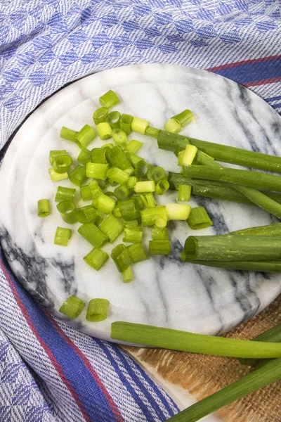 Small cut and wet spring onions on marble — Stock Photo, Image