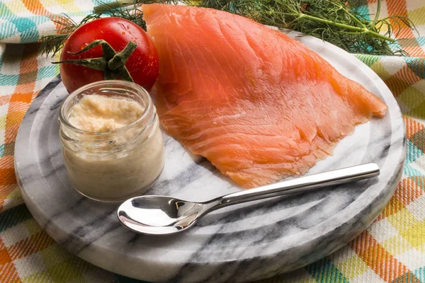 Räucherlachs mit Tomate und Meerrettich auf einem Marmorteller — Stockfoto