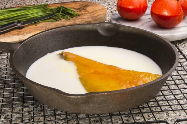 Filet d'aiglefin fumé préparé dans une casserole en fonte avec du lait — Photo