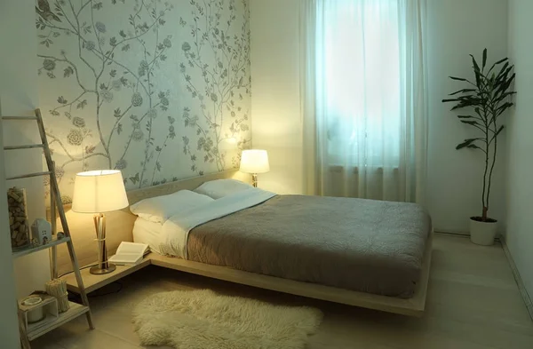 The interior of the bedroom with with lighted lamp