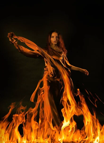 Concept art photo of a middle-aged red-haired woman symbolizing fire on a black backgroun