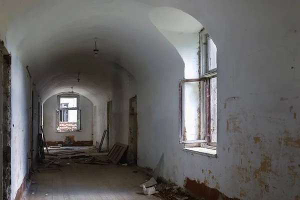 Inside of old creepy abandoned mansion. A light shines through the window. The oppressive atmosphere of the Apocalypse