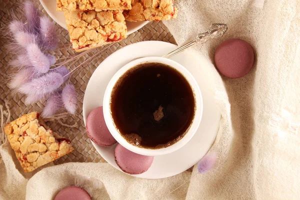 紫のマカロン ビスケット ソーサーとスプーンで白いカップ — ストック写真