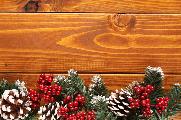 Spruce branches, cones and red berries on a white wooden background. Background for christmas and new year