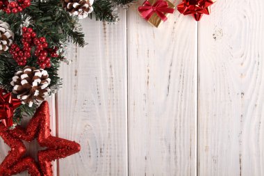 Çam dalları, koni ve beyaz ahşap zemin üzerinde kırmızı meyveler. Noel ve yeni yıl için arka plan