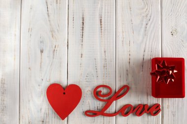 Ahşap mektupları Kupa Beyaz ahşap zemin üzerinde sevgi ve kırmızı. Arka plan veya kartpostal