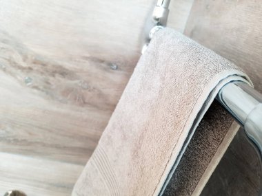 Tüm kahverengi tonlarında bir ısıtmalı havlu ray üzerinde banyoda havlu asmak