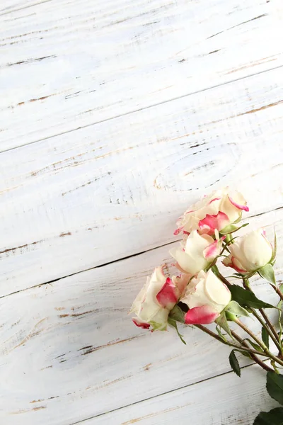 Bílé růže na dřevěném pozadí — Stock fotografie