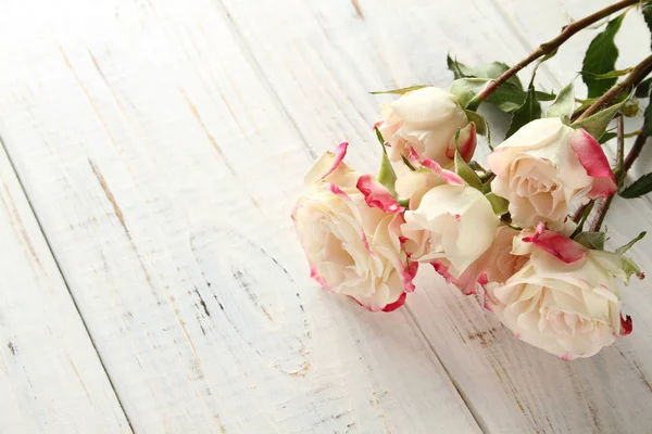 Białe róże na drewnianym tle — Zdjęcie stockowe