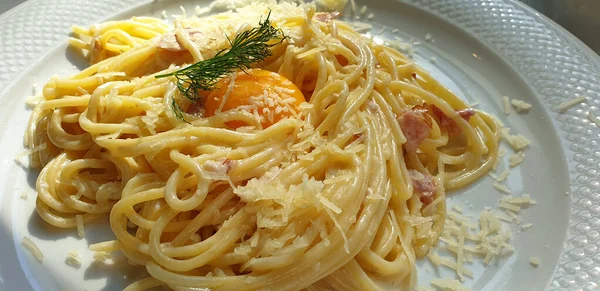 Makaron Carbonara Szynką Serową Żółtkiem Leży Talerzu — Zdjęcie stockowe