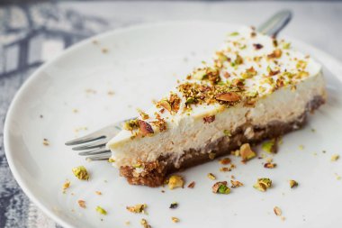 Vanilyalı cheesecake üzerine kavrulmuş fıstık (seçici odak))