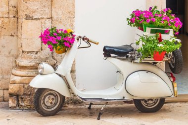Martina Franca, Puglia, İtalya - 05 / 31 / 2018 - Eski kasabadaki bir mağazanın önünde çiçekli bir Vespa scooter