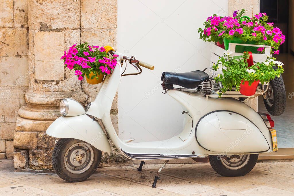 Martina Franca, Puglia, Italy - 05/31/2018 - A decorative Vespa scooter with flowers in front of a store in the old town