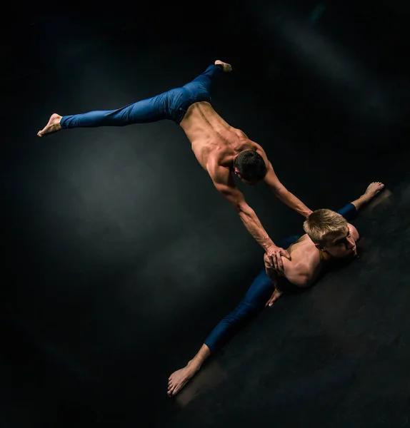 Mannelijke Acrobatische Duo Voert Een Ingewikkelde Balanceeract Een Donkere Achtergrond — Stockfoto