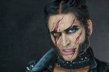 Profesyonel makyaj kurt adam Wolverine izleri ve turuncu göz ile.