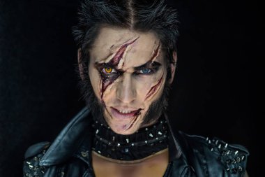 Profesyonel makyaj kurt adam Wolverine izleri ve turuncu göz ile.