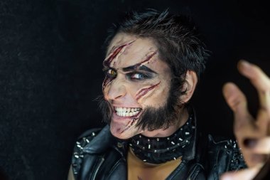 Profesyonel makyaj kurt adam Wolverine izleri ve turuncu göz ile.