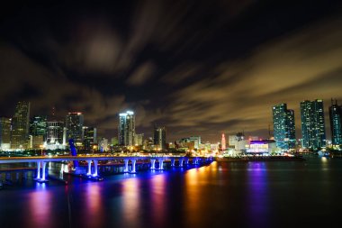 Miami şehir manzarası panorama ile kentsel gökdelenler ve köprüden denize ile yansıma alacakaranlıkta