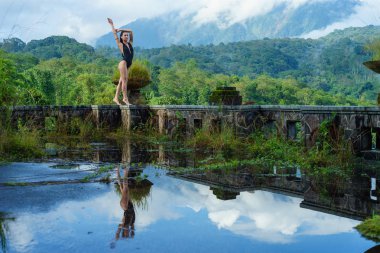 Mistik terk edilmiş çürük bir otel Bali mavi gökyüzü ile mayoyla kız. Endonezya.