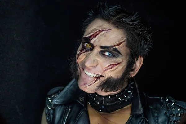 Profesyonel makyaj kurt adam Wolverine izleri ve turuncu göz ile.
