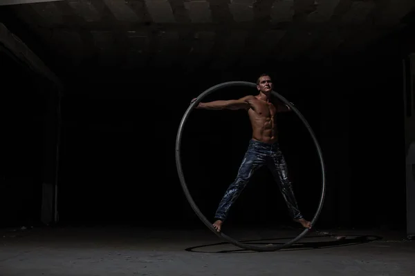 肌肉马戏团艺术家在一个黑色的背景西尔车轮 — 图库照片