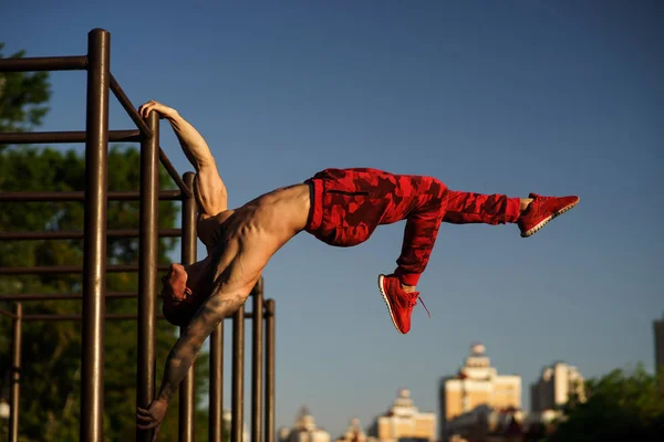 Kaslı adam sokakta bayrak yapma. Sokak egzersiz.