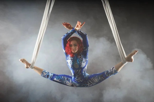 Спортивний сексуальний повітряний цирк художник з рудою в синьому костюмі танцює в повітрі з балансом — стокове фото