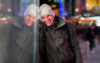 Palto ve şapka gece şehrin bulanık ışıkları zemin üzerine giymiş yakışıklı genç