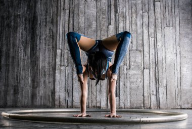 Genç kadın Acrobat ayakta yandan fotoğraf Studio gri arka plan üzerinde. Esnek kadın sirk jimnastik, jimnastik amut.