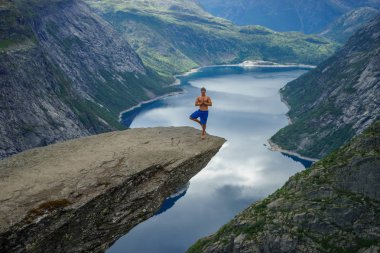 Yog kenarında Trolltunga dua ediyor. Norveç