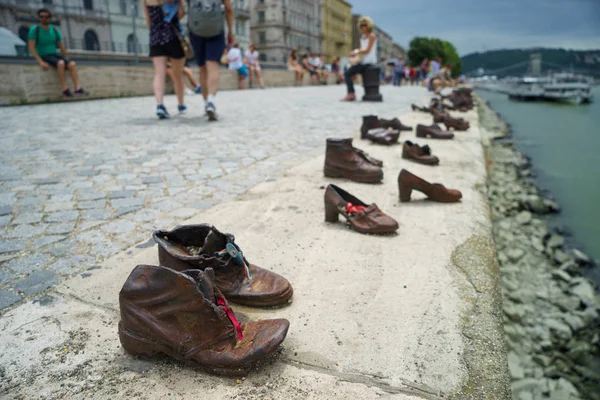 Metal shoes on the Danube promenade with blurred people on background — Stock Photo, Image