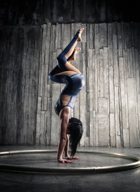 Genç kadın Acrobat ayakta yandan fotoğraf Studio gri arka plan üzerinde. Esnek kadın sirk jimnastik, jimnastik amut.