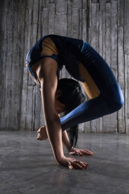 Genç kadın Acrobat ayakta yandan fotoğraf Studio gri arka plan üzerinde. Esnek kadın sirk jimnastik, jimnastik amut.