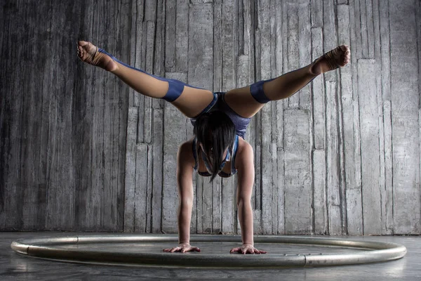 Genç kadın Acrobat ayakta yandan fotoğraf Studio gri arka plan üzerinde. Esnek kadın sirk jimnastik, jimnastik amut.