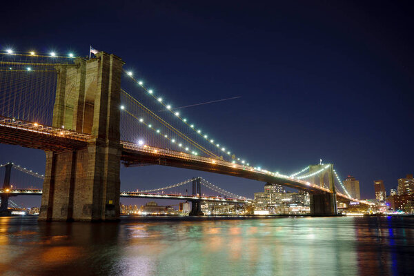 Manhattan Bridge and Brooklyn Skyline with nice blurred reflection in the river at night