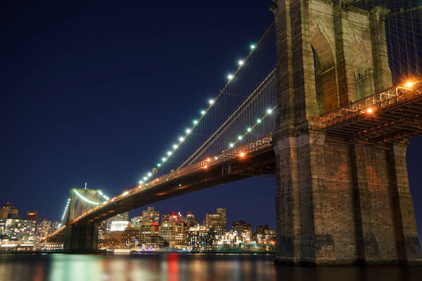 Manhattan Bridge and Brooklyn Skyline with nice blurred reflection in the river at night