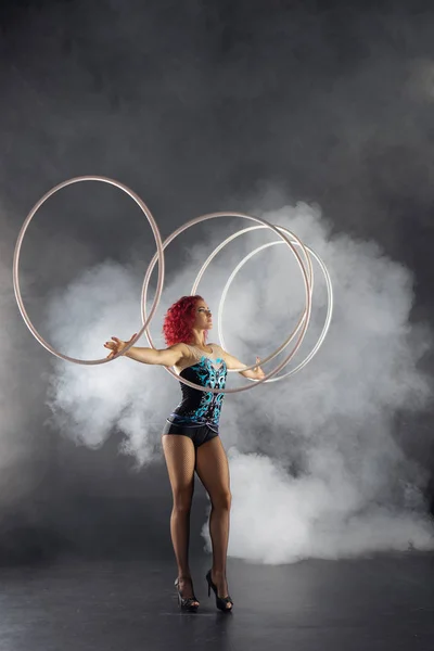 Belle fille avec des cheveux roux artiste cirque filature cerceaux sur les mains — Photo
