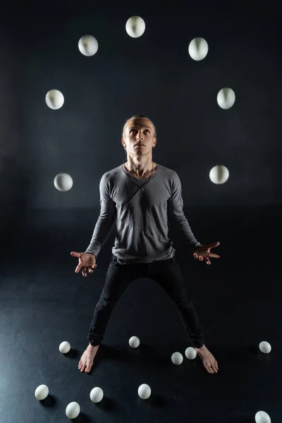 Blond juggler with white balls on black background — Stock Photo, Image