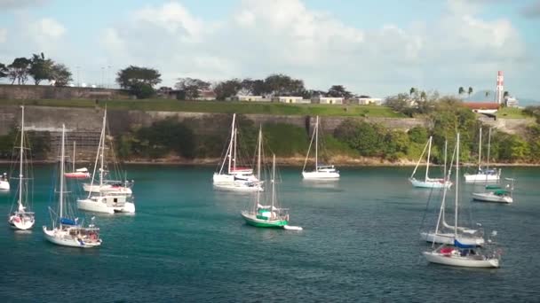 Luxury yachts anchored in the blue water with fort on background — Stock Video