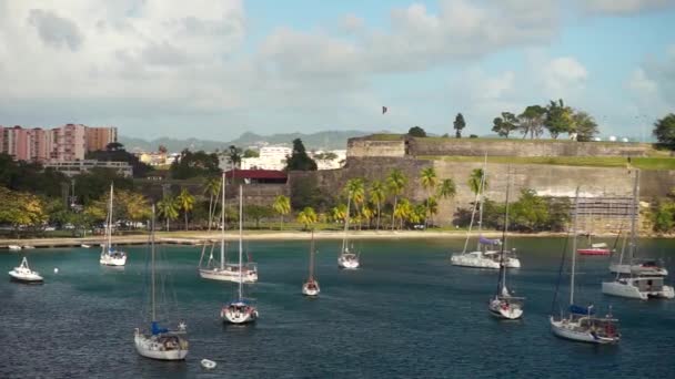 Luxusjachten vor Anker im blauen Wasser mit Festung im Hintergrund — Stockvideo
