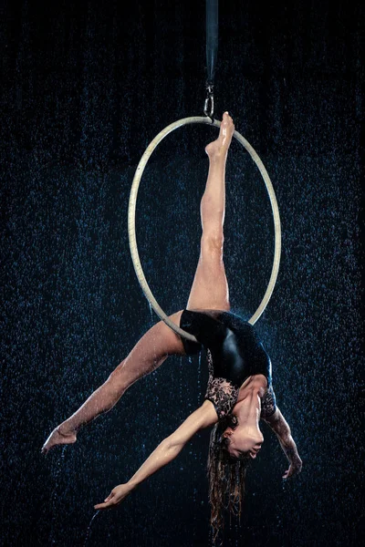 Ung vacker smal cirkusartist på aerial hoop poserar på en svart aqua studio bakgrund. — Stockfoto