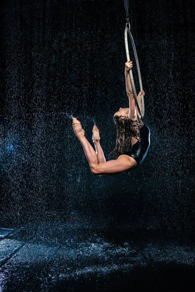 Een jong meisje voert de acrobatische elementen in de antenne ring. Aqua Studio schieten optredens op een zwarte achtergrond — Stockfoto