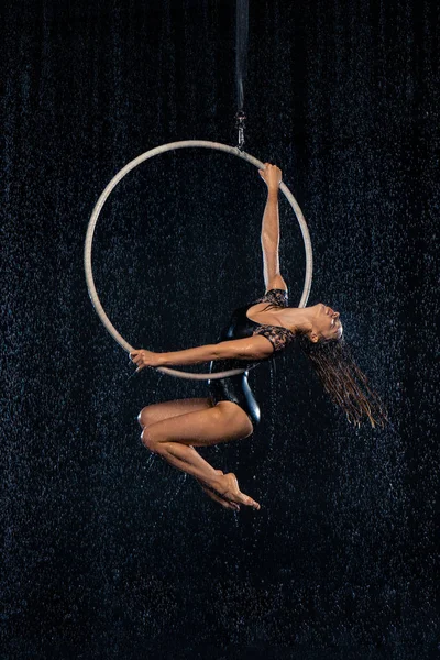 Ein junges Mädchen führt die akrobatischen Elemente im Luftkorb vor. schwarzes Aqua Studio — Stockfoto